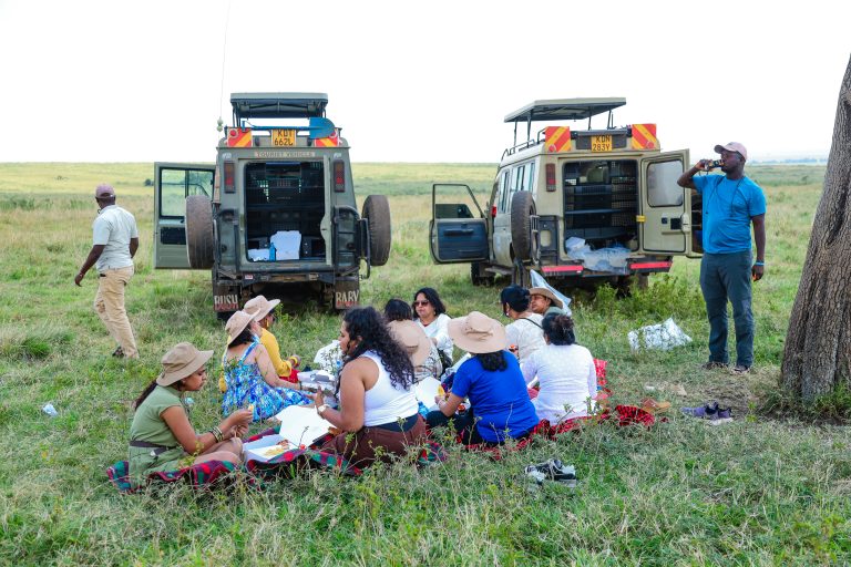 Safari clients enjoying bush lunch after a successful game drive in Masai Mara National reserve in Kenya