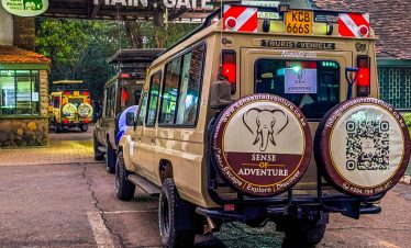 A customized safari jeep parked at the main entrance of Nairobi National Park ready for a wildlife safari adventure.