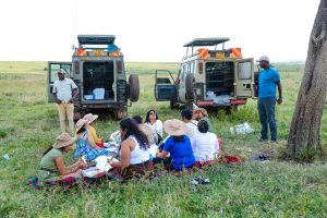 Large family group on safari in Maasai Mara gathered in a 4x4 vehicle watching wildlife on the savannah