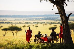 Romantic honeymoon safari in Kenya featuring a luxury lodge, scenic savannah views, and a couple enjoying a private sunset experience in the wild