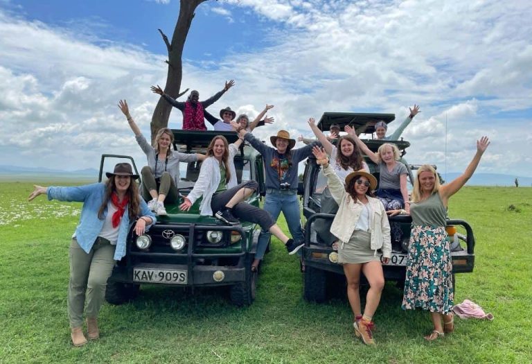 Group of safari clients enjoying a game drive in Maasai Mara National Reserve, Kenya Safari, spotting wildlife across the open savannah during a shared safari experience