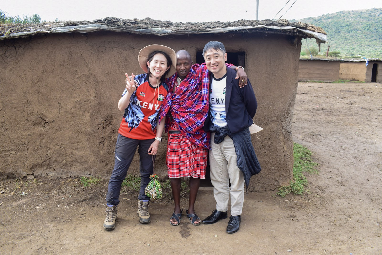 Guests posing outside a Maasai manyatta homestead during a cultural visit