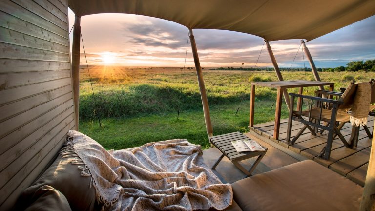 Sunrise view over the Masai Mara plains from a tent deck at &Beyond Kichwa Tembo