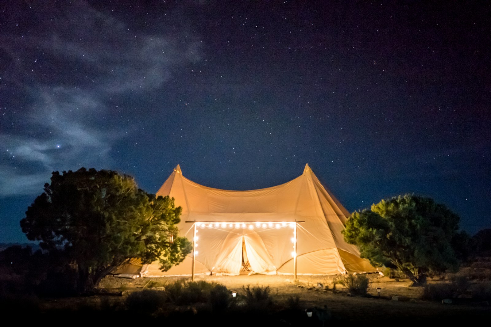 Safari tent safety: a canvas tent glowing under a clear, starry night sky