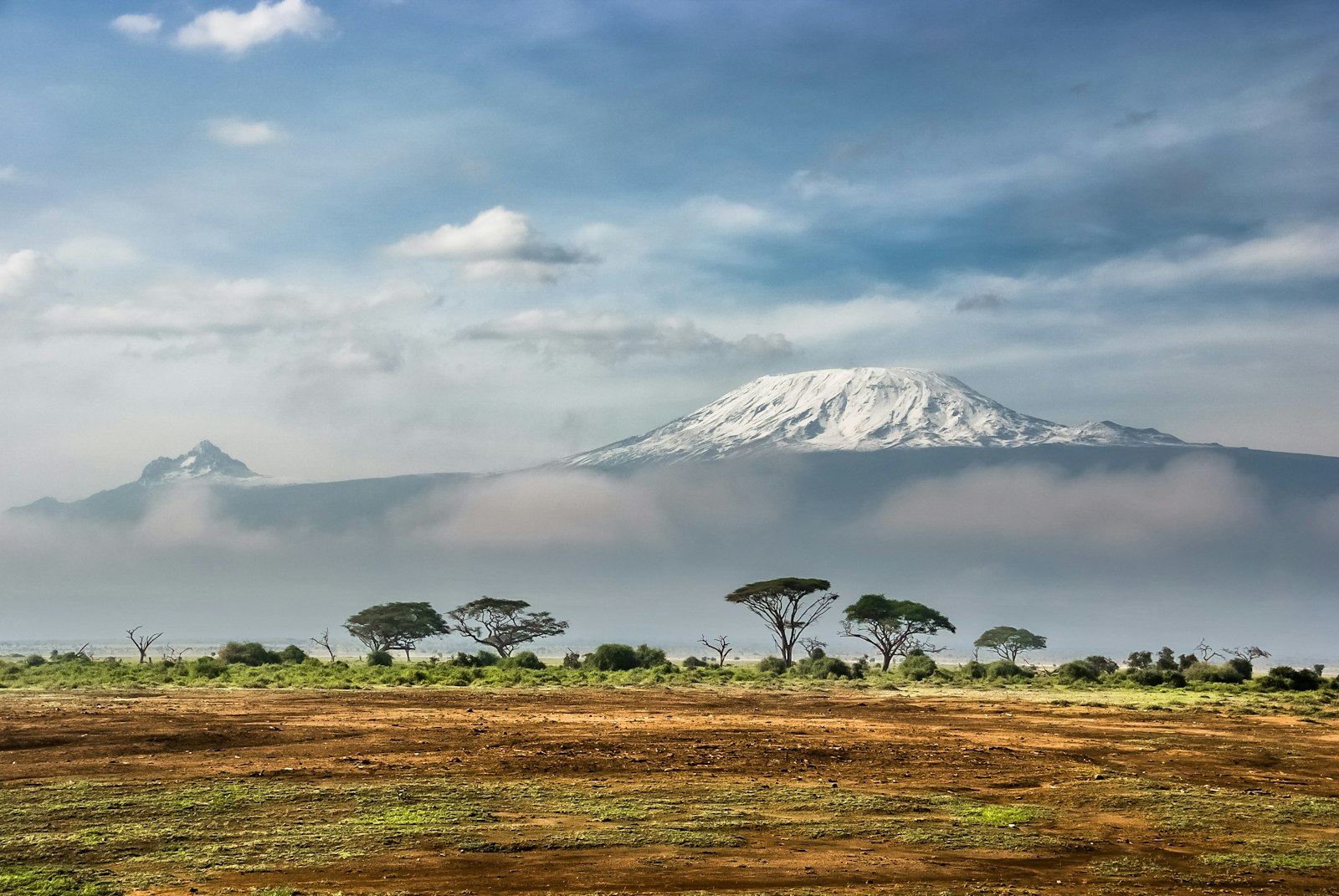 Snow-capped Mount Kilimanjaro rising above clouds, seen from Amboseli National Park in Kenya
