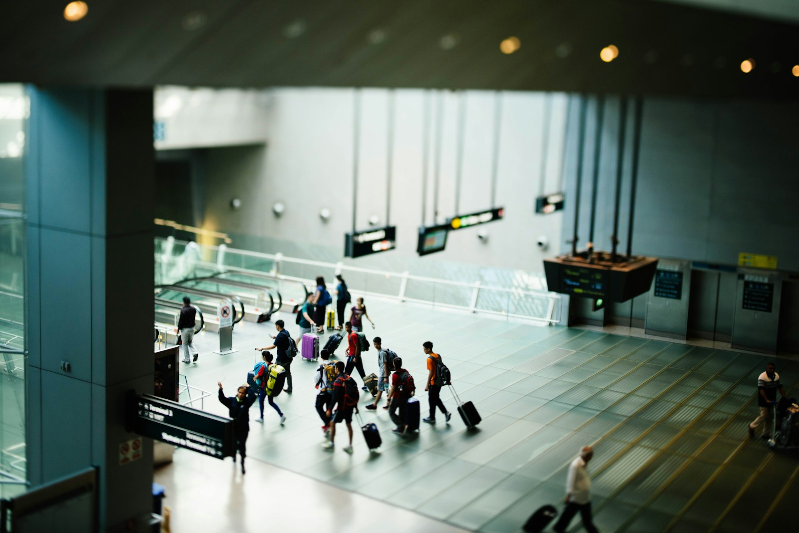Group of travellers with luggage walking through an airport terminal after arrival