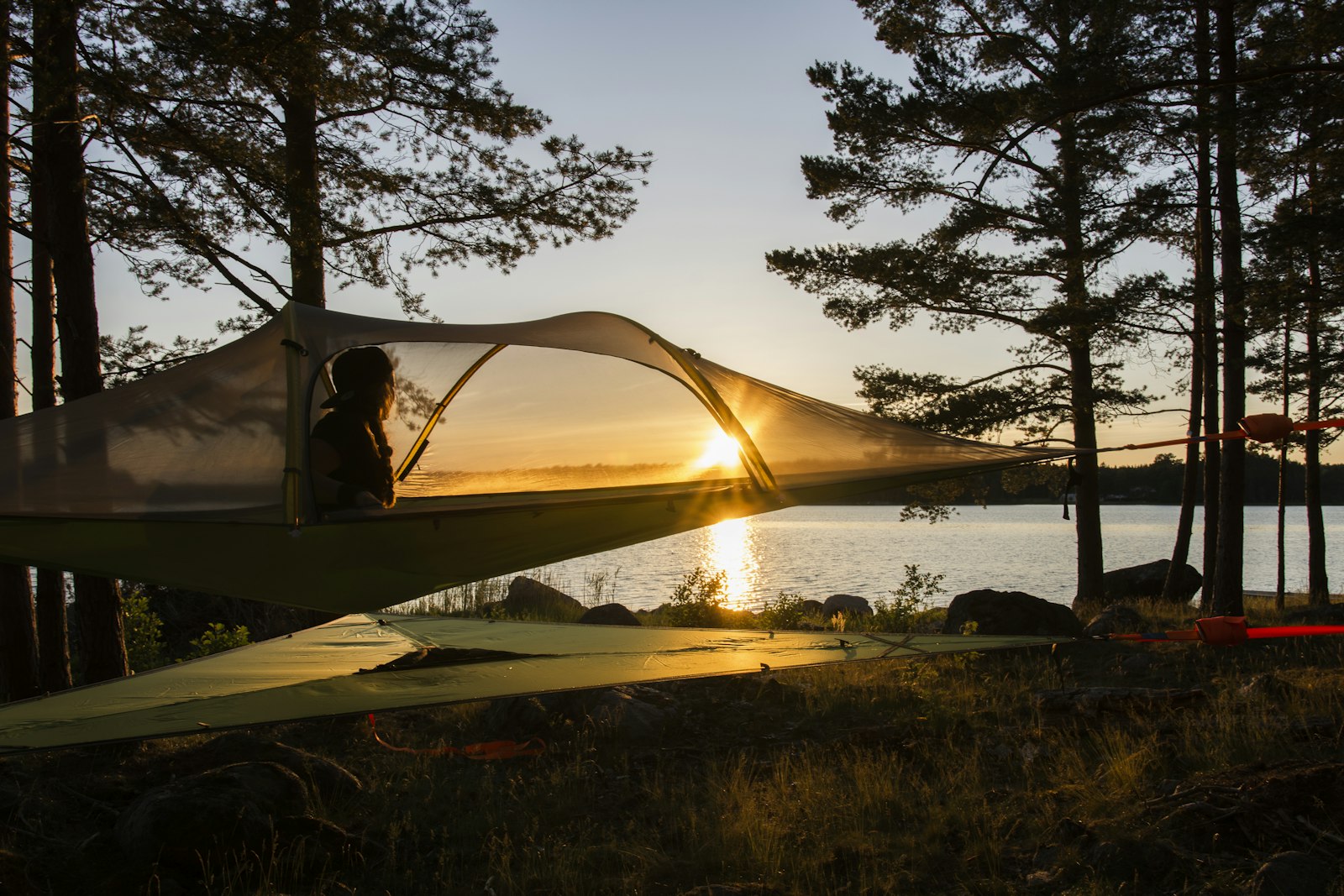 Canvas safari tent beside a river at sunset, when mosquitoes become active