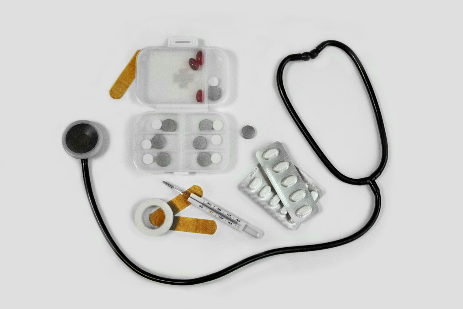 Thermometer, pill organiser, blister packs and plasters for a safari travel medicine kit