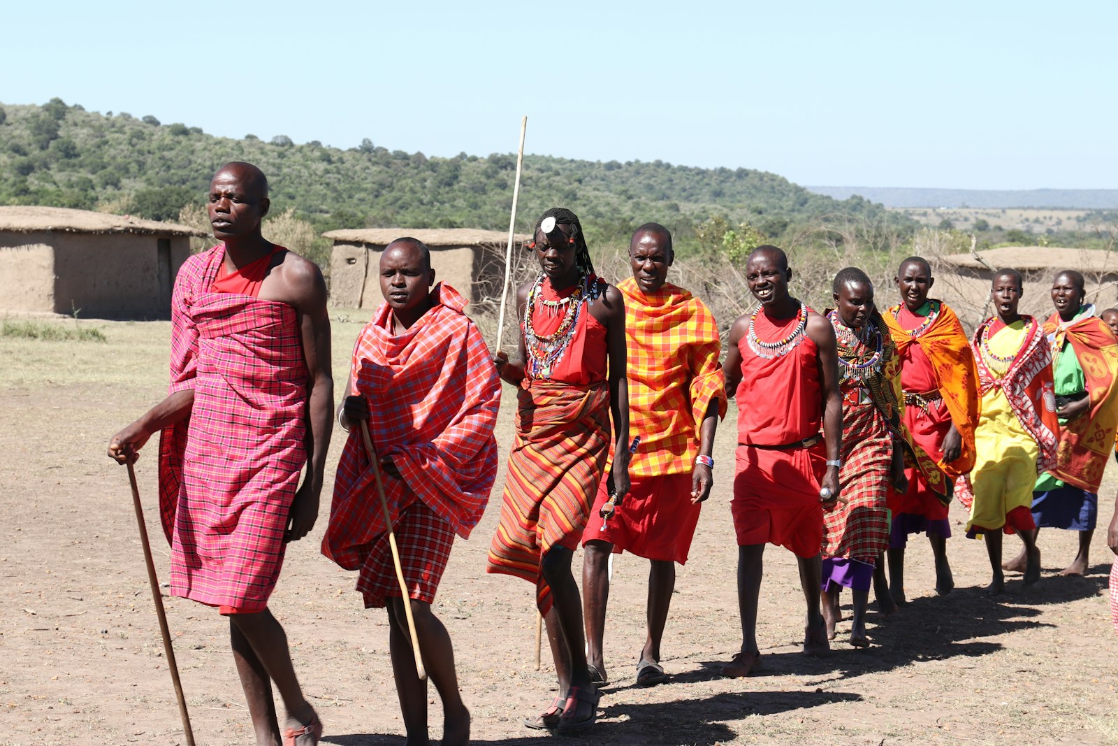 Group of people wearing bright orange and yellow traditional dress outdoors