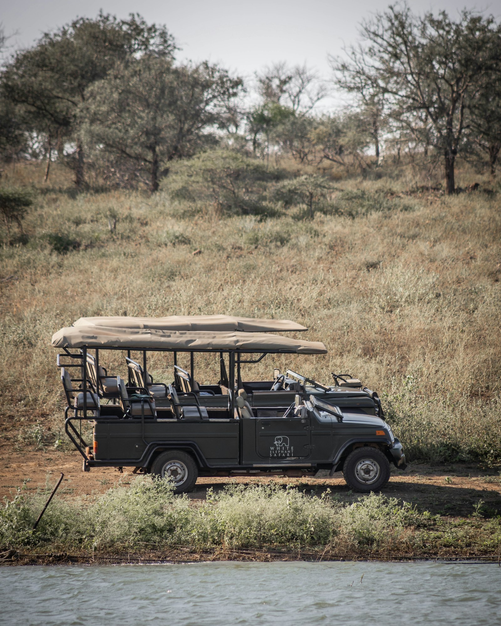 Safari vehicle parked on open savanna grassland during a game drive in Kenya