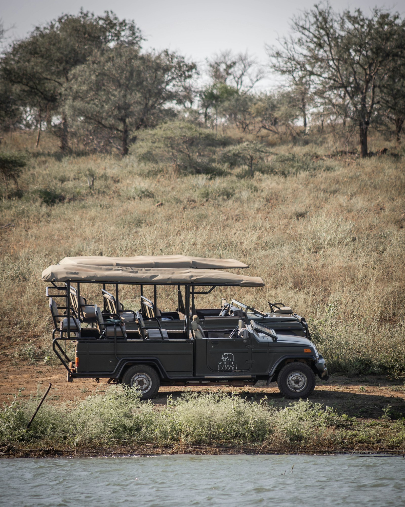 Safari vehicle parked in a grassy field during a game drive in Africa