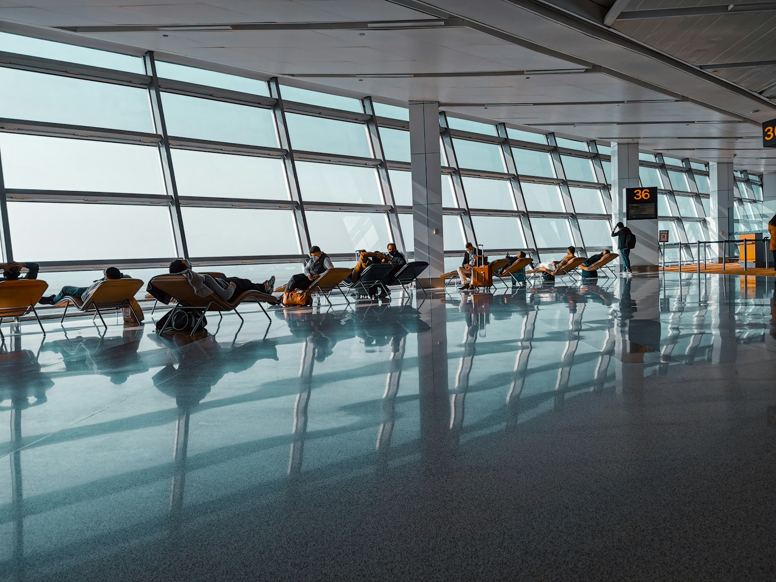 Travellers relaxing in one of the JKIA lounges beside large windows between flights
