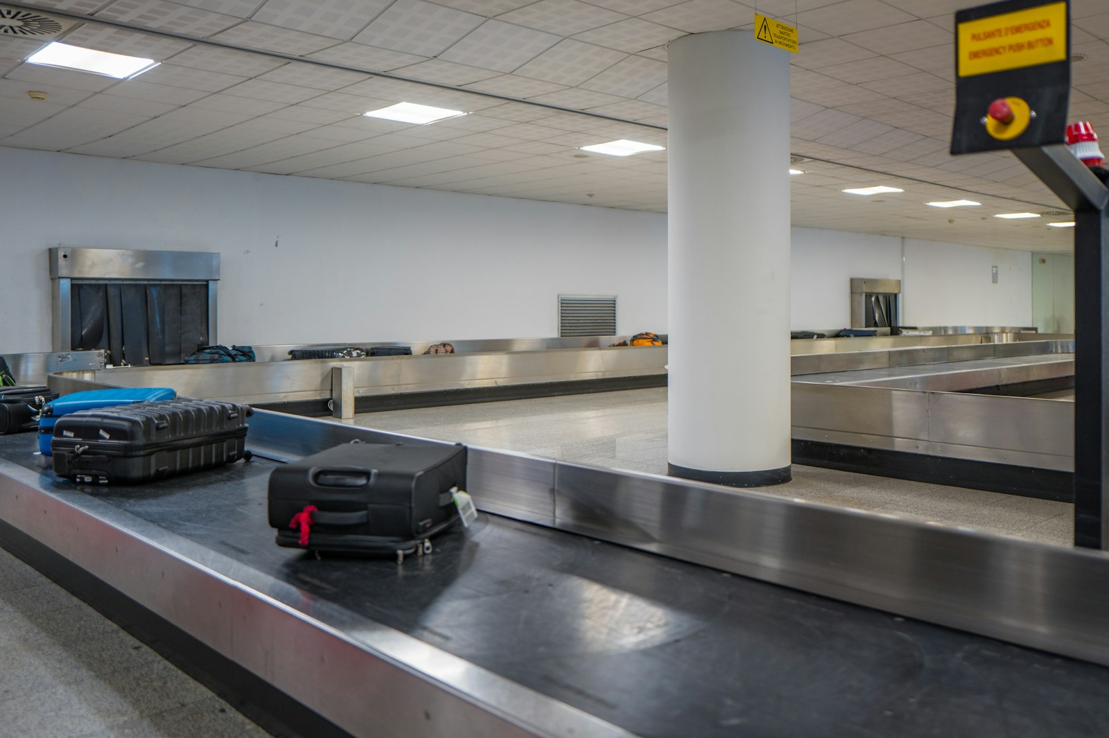 Checked luggage moving along a conveyor belt at an airport baggage claim hall