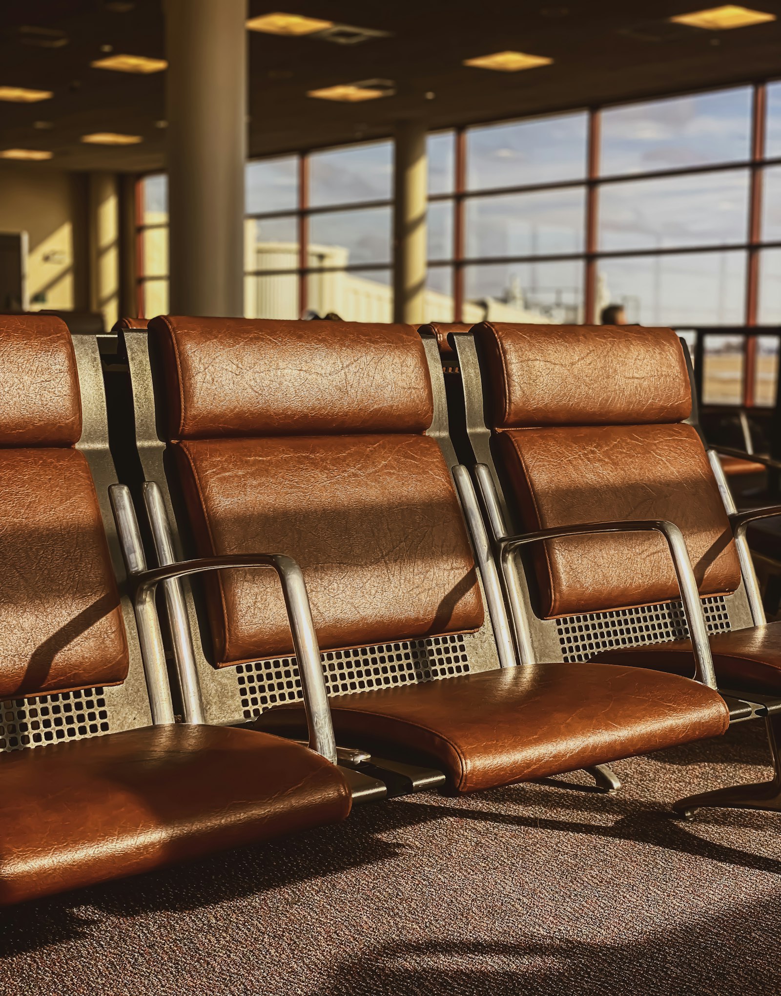 Quiet airport waiting area with leather seats, where travellers rest when a layover is too short