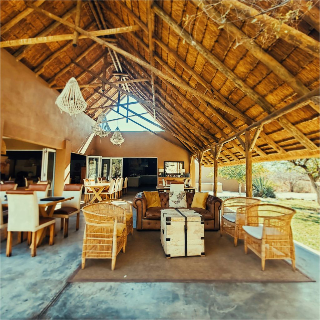 African safari cost guide: an open-air safari lodge lounge with a thatched roof