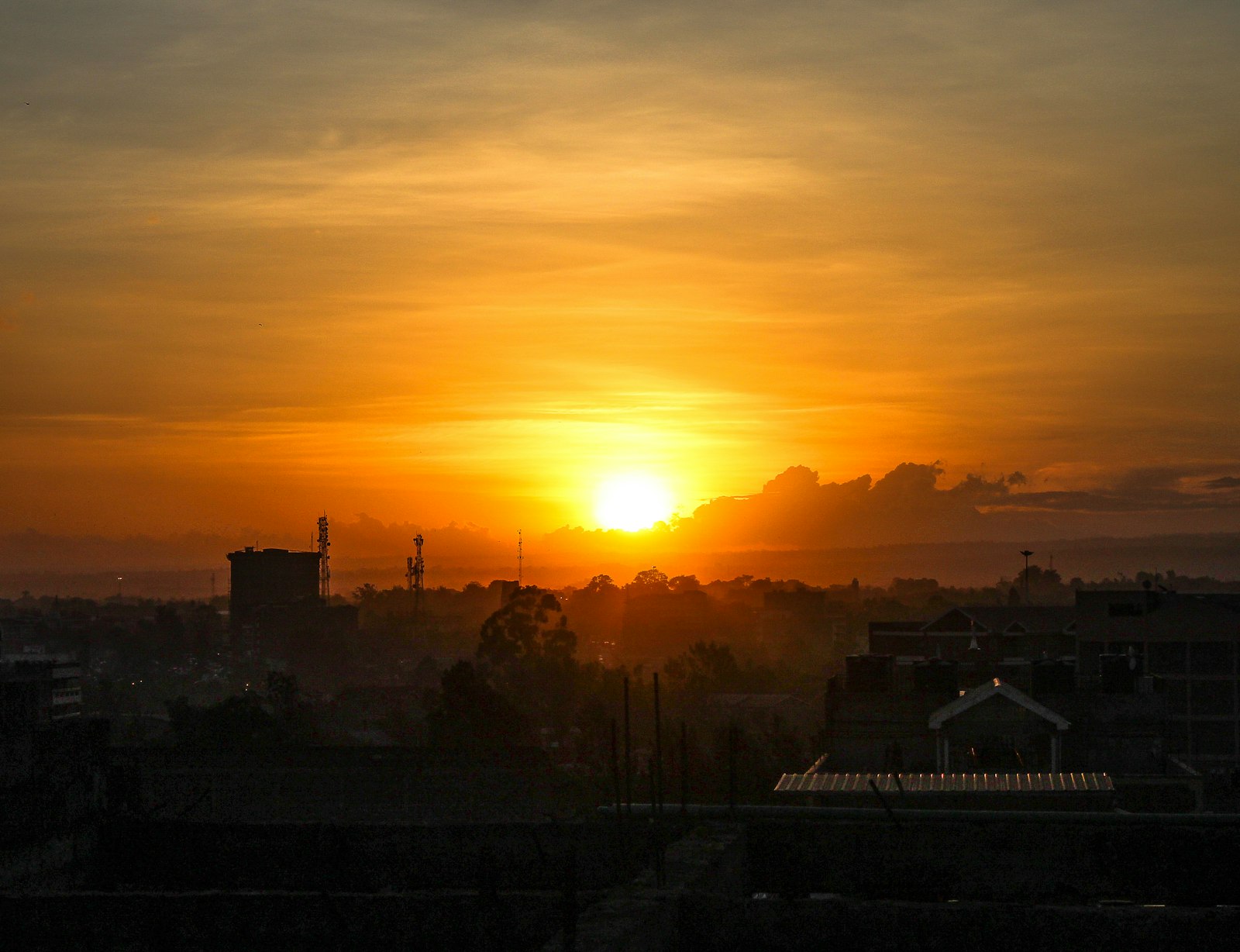 Vivid orange sunset over a silhouetted city skyline as evening falls over Nairobi